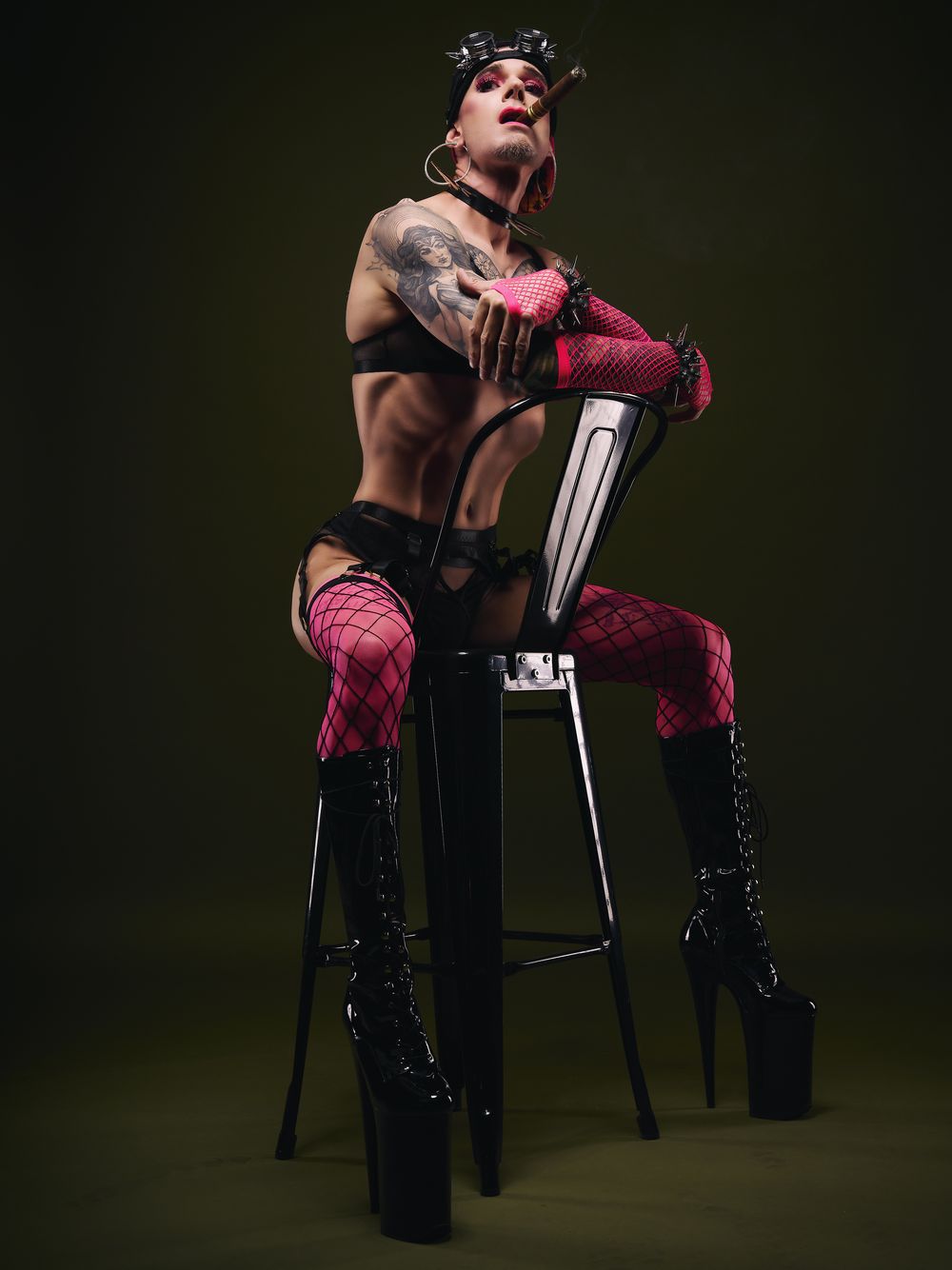 Stilisiertes Fetisch-Porträt in Netzstrümpfen und Plateaustiefeln mit Cigarre – Queer Fotografie von Hell On Heels aus Düsseldorf